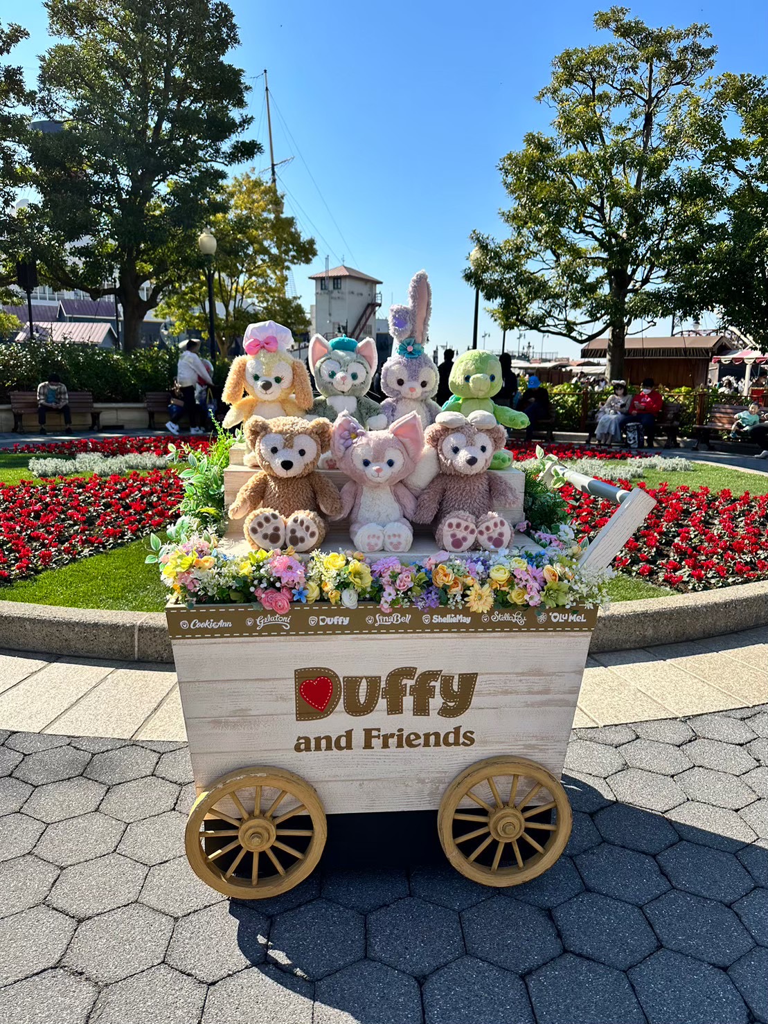 花で飾られたワゴンに座る、ダッフィーやシェリーメイなど「Duffy and Friends」のぬいぐるみたちの展示。
